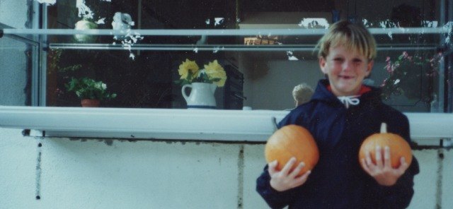 Aaron outside their kitchen window, holding his winnings from the Pumpkin Meet at Golden West College. Photo courtesy of Wella Hartig.