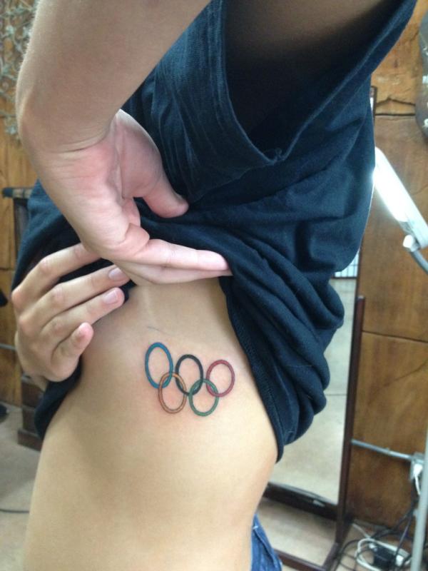 Minimalist Olympic rings tattoo on the inner forearm
